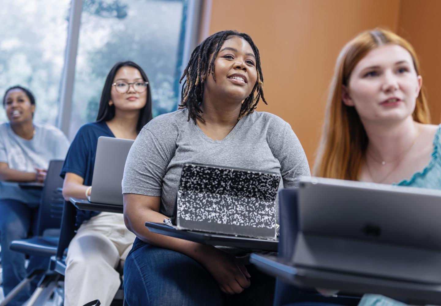 Students in a classroom, watching a lecture